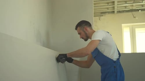 Mechaniker macht mit einem Bleistift Notizen an der Wand
