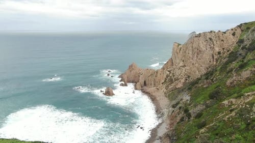 Couple Stands on Edge of Cliff in Ocean Drone Flies Overhead