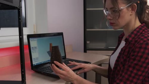 Female Designer Holding a 3D Printed Prototype That Has Just Come Off the Printer