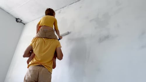Father and Child Painting a Wall Together