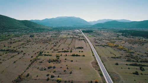 Empty Asphalt Road on the Plateau Between Green Fields Highland Way Aerial View