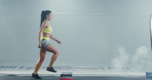 Fit Woman Does Step Aerobics in Bright Studio