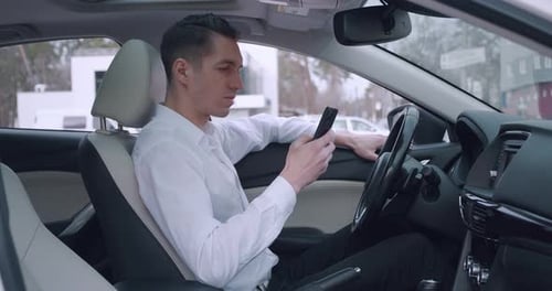 Man Using Phone While Sitting in His Car