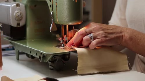 Closeup view of womans hands sewing fabric with a vintage, retro sewing machine.