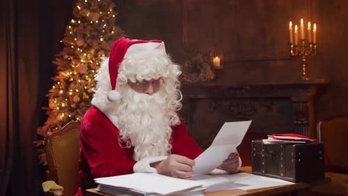 Santa Reading Letters at Desk Takes off Costume