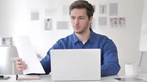 Man Works on Laptop in Bright Office