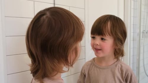 Nettes Kind untersucht sich selbst im Spiegel