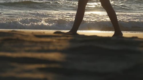 Legs of Young Woman Stepping at Sand. Close Up of Female Feet Walking on Golden Sand at the Beach
