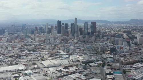 AERIAL: Slowly Circling Downtown Los Angeles Skyline with Warehouse Art District in Foreground with