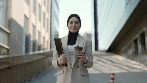 Business Lady in Hijab with Coffee and Clipboard in Hands