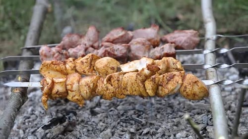 Marinated shashlik or shish kebab preparing on a barbecue grill over charcoal. Skewered meat