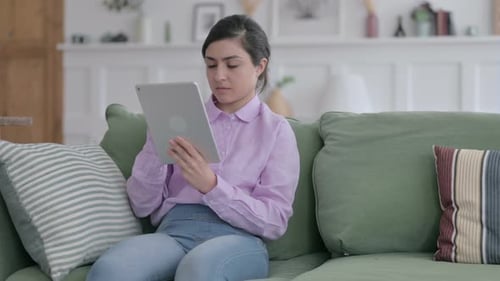 Young Adult Using Tablet Sitting on Couch