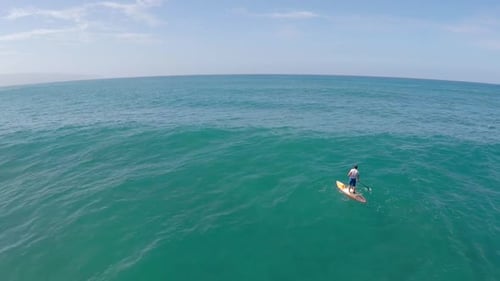 Aerial view of a man sup stand-up paddleboard surfing in Waimea, Hawaii