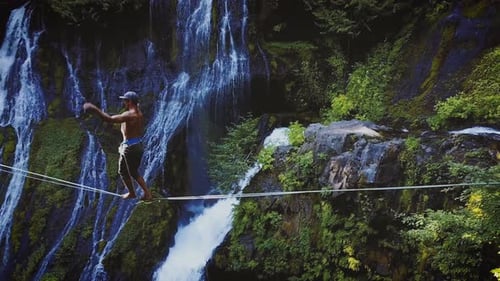 Fit Man High-lining Over A Waterfall