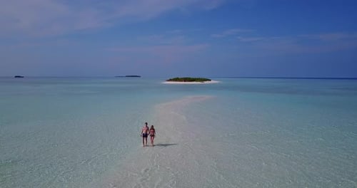 Happy couple on honeymoon vacation spend quality time on beach on sunny white sandy 4K background