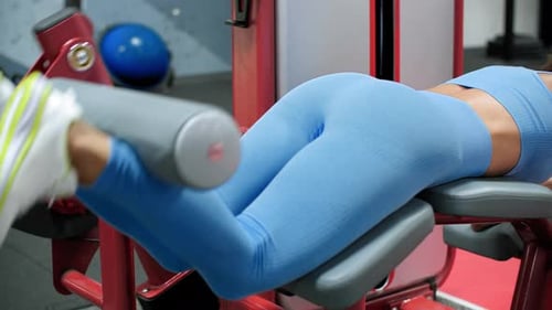 Sport Woman Training Leg Muscles in Weight Trainer in Fitness Club. Female Bodybuilder Doing Legs