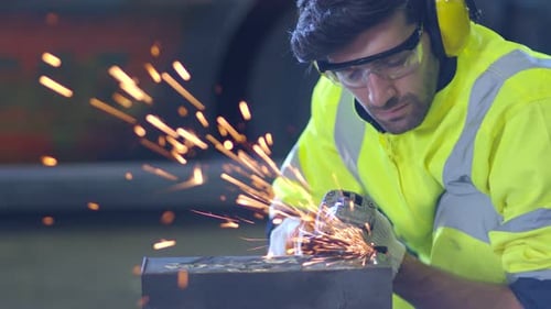 Industrial Worker Grinding Metal with Flying Sparks