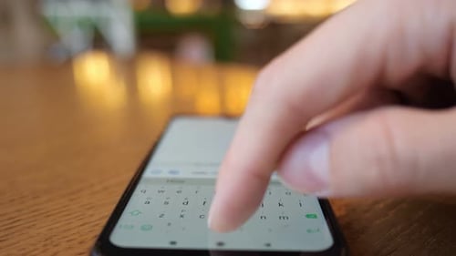 La main d'un jeune homme saisit un message au téléphone et l'envoie