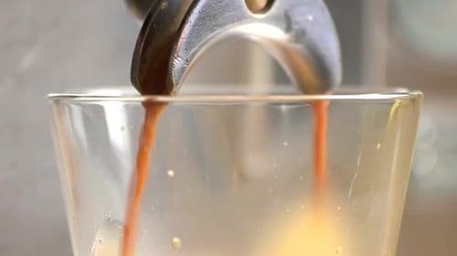 Espresso Being Poured From Coffee Maker into Cup