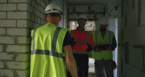 Contractors with Tablet Examining Unfinished Building