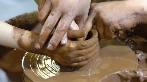 La roue du potier et les mains du potier.