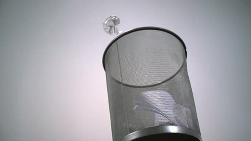 Paper Ball Thrown Into Metal Mesh Trashcan