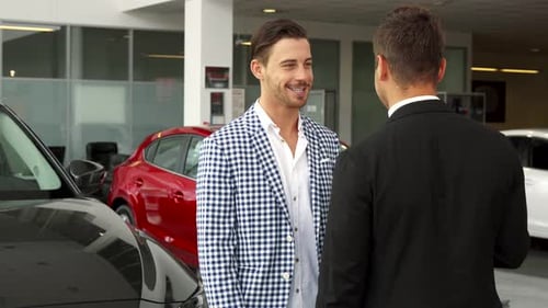 Man Shakes Hands in Modern Car Dealership