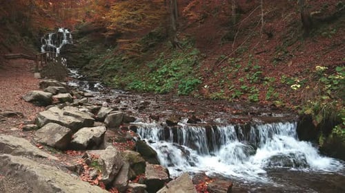 Waterfall Falling Down Mountain Slope in Autumn Forest