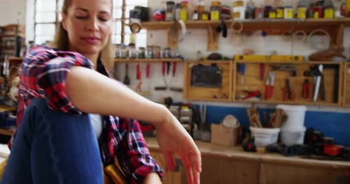 Woman Smiling in a Cluttered Workshop