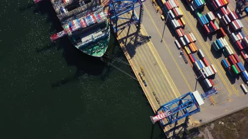 Container ship in export and import business and logistics. Shipping cargo to harbor by crane. Water