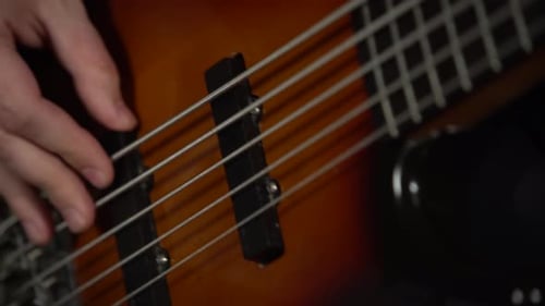Professioneller Musiker spielt auf E-Gitarre in einem dunklen Studio mit Rauch- und Neonbeleuchtung