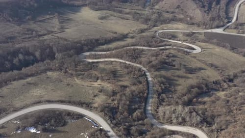 Ascending over the hill and curvy road 4K aerial footage
