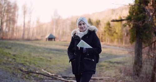 Fair-Haired Woman Holding Map on a Wooded Path