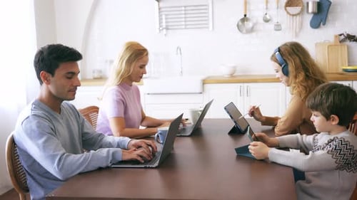 Family Working Together at Table Using Technology