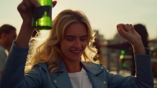 Woman Dancing at Rooftop Party in Golden Light