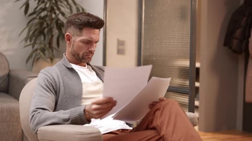 Man Looking Through Documents at Home