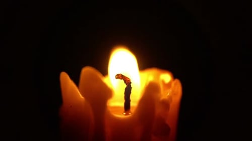 Candle Flame Flickering in the Darkness