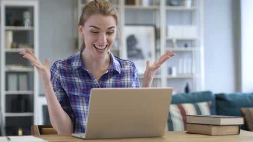 Woman Working on Laptop at Home Celebrates Success