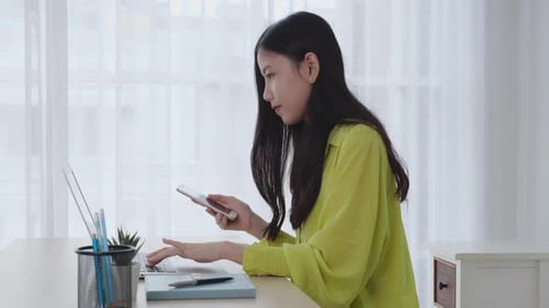 Young asian businesswoman working on laptop computer online on desk at home office.
