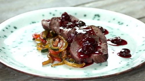 Close up of Meat with Vegetables and Dark Sauce