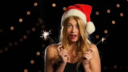Joyful Woman with Sparklers Wearing Santa Hat