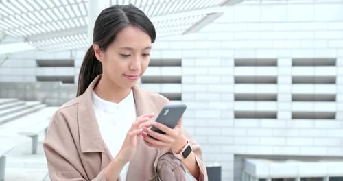 Woman Using Cellphone in Modern Urban Setting