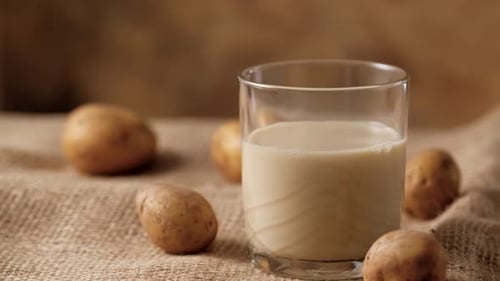 Potato Milk With Potatoes on Burlap Surface