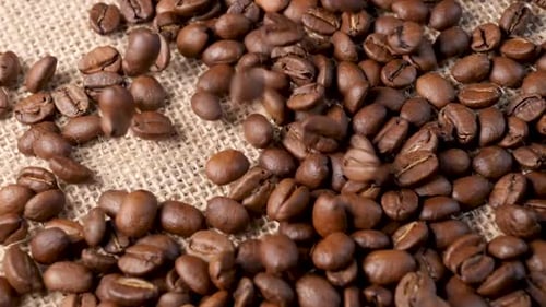 Geröstete Kaffeebohnen. Zeitlupe fallender Arabica-Kaffeesamen
.