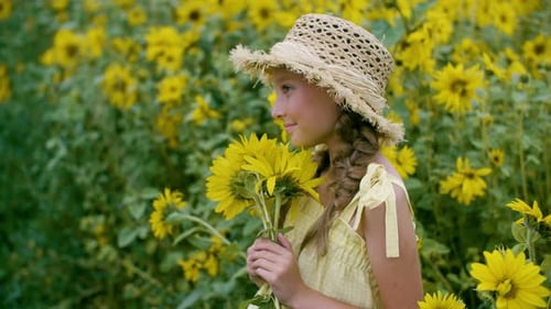 Girl Holds Sunflowers in Blooming Field