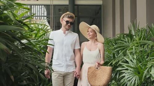 Couple en vacances marchant le long du complexe tropical