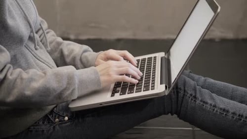 Young Adult Typing on Laptop at Home