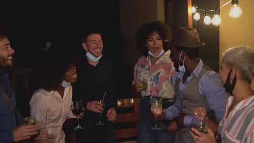 Friends Celebrate Outdoors at Night with Drinks