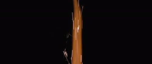 Feuer und orangefarbene Funken kommen aus einem Feuerwerk.