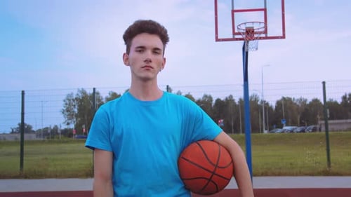 Young Adult with Basketball on Outdoor Court
